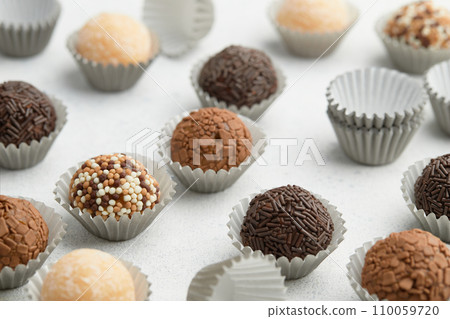 Typical Brazilian sweet brigadeiro. Assorted flavors of candies on a white table. Pattern 110059720