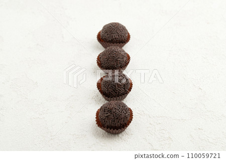 Typical Brazilian sweet brigadeiro. Line of chocolate candies on a white background Typical Brazilian sweet brigadeiro. Line of chocolate candies on a white background 110059721