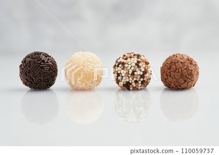 Typical Brazilian sweet brigadeiro. Line of candies with different tastes on a marble background Typical Brazilian sweet brigadeiro. Line of candies with different tastes on a marble background 110059737