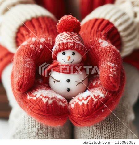 Close up of hands in red wool mittens holding a small snowman. Close up of hands in red wool mittens holding a small snowman. 110060095