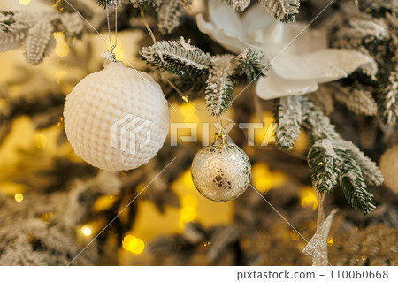Close up view of beautiful fir branches with shiny white baubles or balls, golden xmas ornaments and lights. Holidays background. Decoration on christmas tree. Festive new 2024 year. Copy space. Close up view of beautiful fir branches with shiny white baubles or balls, golden xmas ornaments and lights. Holidays background. Decoration on christmas tree. Festive new 2024 year. Copy space. 110060668