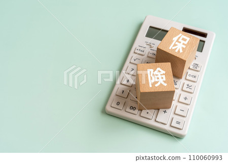 A block with the word ``insurance'' on it and a calculator A block with the word ``insurance'' on it and a calculator 110060993