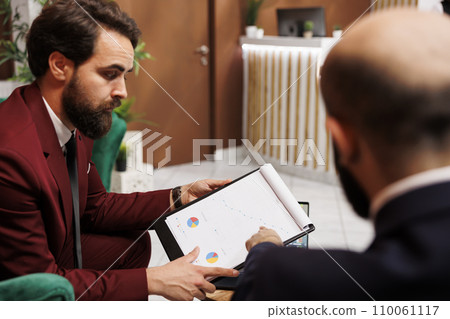 Businessmen forging new alliances, looking to expand corporate activity internationally at important meeting. Entrepreneurs working to establish fruitful international partnerships, hotel reception. 110061117