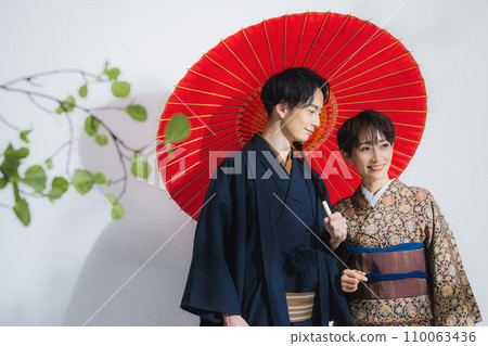 A man and a woman in kimono with umbrellas A man and a woman in kimono with umbrellas 110063436
