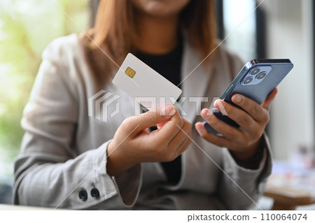 Businessman holding plastic card making online payment purchase or transferring money in ebank app. Businessman holding plastic card making online payment purchase or transferring money in ebank app. 110064074