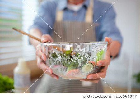 Closeup senior man holding bowl of healthy fresh vegetarian salad. Healthy food, dieting, vegan food concept. Closeup senior man holding bowl of healthy fresh vegetarian salad. Healthy food, dieting, vegan food concept. 110064077