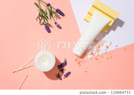 White tube on pink backdrop with Himalayan pink salt, lavender flowers, scented candles, and matches. Perfect for branding with blank labels. Elevate your self-care ritual. 110064731