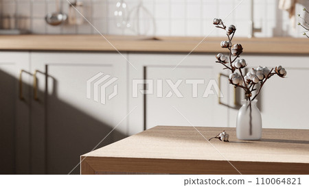 A bright beige-toned kitchen interior with sunlight coming through the window. 110064821
