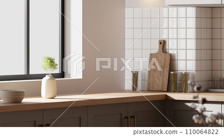 A bright beige-toned kitchen interior with sunlight coming through the window. A bright beige-toned kitchen interior with sunlight coming through the window. 110064822