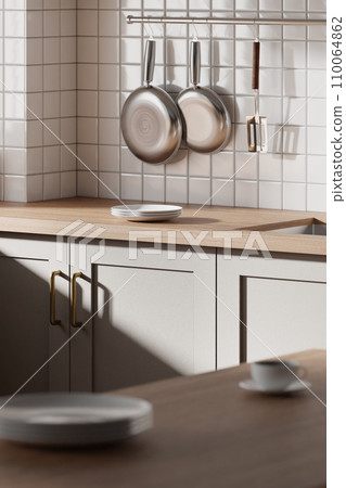 A bright beige-toned kitchen interior with sunlight coming through the window. 110064862