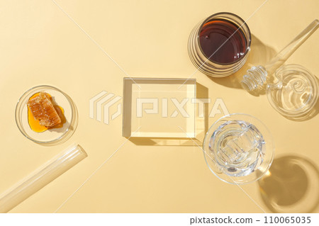 On a pastel background, an empty glass podium sets the stage for product display, featuring stored honey in glassware. Honey accelerates skin cell recovery, addressing a key factor in eczema. On a pastel background, an empty glass podium sets the stage for product display, featuring stored honey in glassware. Honey accelerates skin cell recovery, addressing a key factor in eczema. 110065035