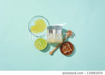 Honey in a petri dish, a luxury cosmetic jar, a honey drizzle and lemon are displayed on a pastel background. Honey helps balance bacteria on the skin, helping to protect the skin from infection. Honey in a petri dish, a luxury cosmetic jar, a honey drizzle and lemon are displayed on a pastel background. Honey helps balance bacteria on the skin, helping to protect the skin from infection. 110065059