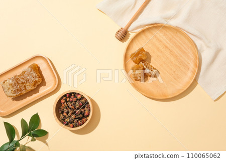 Dried roses are stored in a wooden bowl, and beeswax is displayed on wooden trays. Honey contains many proteins. According to Traditional Medicine, honey has a sweet taste, neutral properties. 110065062