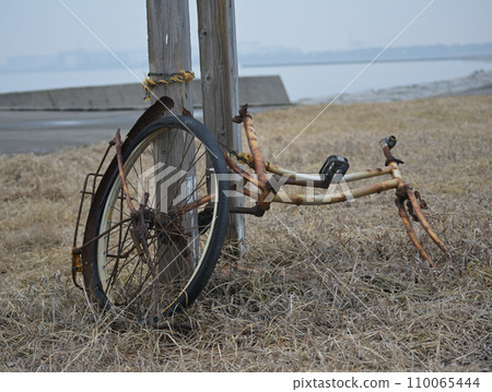 A bicycle left to rot on the beach 110065444