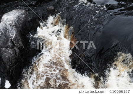 Fast water with foam goes over black rocks. Waterfalls of Ruskeala Fast water with foam goes over black rocks. Waterfalls of Ruskeala 110066137