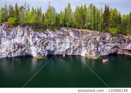 Karelian landscape photo. Tourists in boat sailing the former marble quarry Karelian landscape photo. Tourists in boat sailing the former marble quarry 110066146