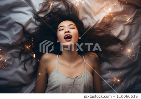 Young Asian woman having orgasm. Beautiful woman with open mouth and closed eyes enjoying sex lying among fireworks. Sparklers as a symbol of orgasm. Sexual experience, masturbation, cunnilingus. Young Asian woman having orgasm. Beautiful woman with open mouth and closed eyes enjoying sex lying among fireworks. Sparklers as a symbol of orgasm. Sexual experience, masturbation, cunnilingus. 110066639