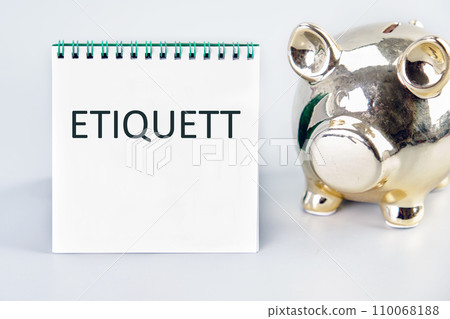 ETIQUETT A word, a text written on a white sheet next to a piggy bank 110068188