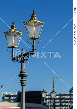 Retro street light shining against the blue sky 110069036