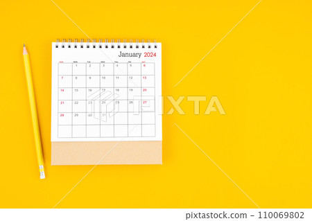 January 2024 desk calendar and wooden pencil on yellow color background. 110069802