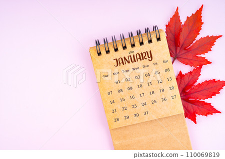January 2024 monthly calendar and fall leaves on pink color background. 110069819