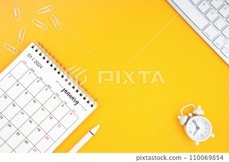 January 2024, Monthly desk calendar for 2024 year and alarm clock with paper clips. January 2024, Monthly desk calendar for 2024 year and alarm clock with paper clips. 110069854
