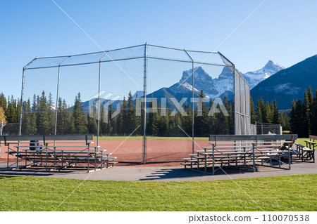 Millennium Park Sport Fields & Playgrounds. Canmore, Alberta, Canada. The Three Sisters trio of peaks over the blue sky in the background. Millennium Park Sport Fields & Playgrounds. Canmore, Alberta, Canada. The Three Sisters trio of peaks over the blue sky in the background. 110070538