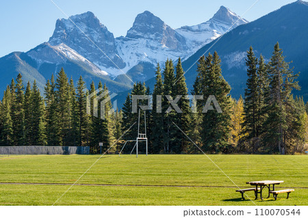 Millennium Park Sport Fields & Playgrounds. Canmore, Alberta, Canada. The Three Sisters trio of peaks over the blue sky in the background. 110070544