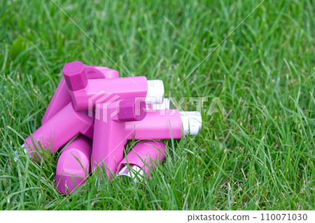 Asthma inhalers on a green grass meadow Asthma inhalers on a green grass meadow 110071030