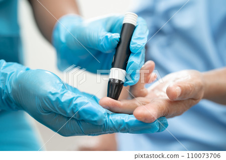Doctor check diabetes from finger blood sugar level with finger lancet. 110073706
