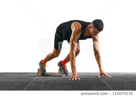 Young athletic man, professional jogger preparing to run while standing at low start against white pristine background. 110074238