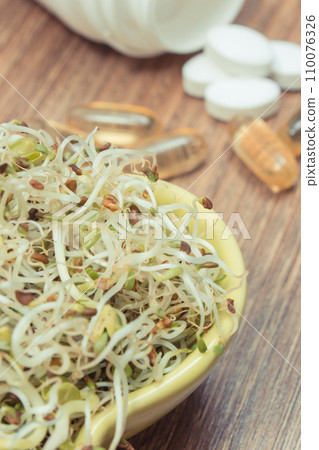 Radish sprouts containing vitamins and tablets supplements. Choice between healthy eating and pills Radish sprouts containing vitamins and tablets supplements. Choice between healthy eating and pills 110076326