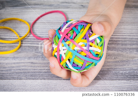 Preschooler hands with ball of rubber bands or erasers. Development of kids motor skills 110076336