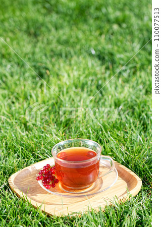 A cup of tea on the green grass background A cup of tea on the green grass background 110077513