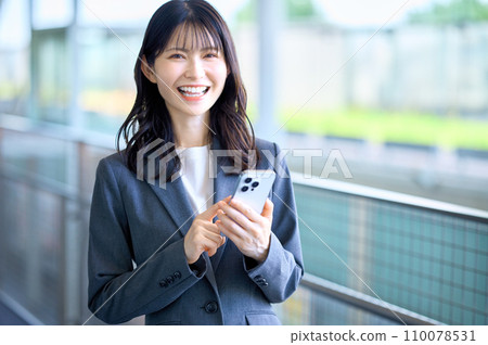 Young business woman in a suit looking at smartphone Young business woman in a suit looking at smartphone 110078531