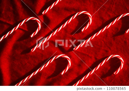 Christmas candy canes on burgundy velvet background. Christmas candy canes on burgundy velvet background. 110078565