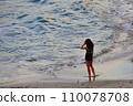 A thoughtful and romantic girl on the seashore at sunset admires the warm sea and clean air 110078708