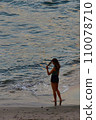 A thoughtful and romantic girl on the seashore at sunset admires the warm sea and clean air 110078710