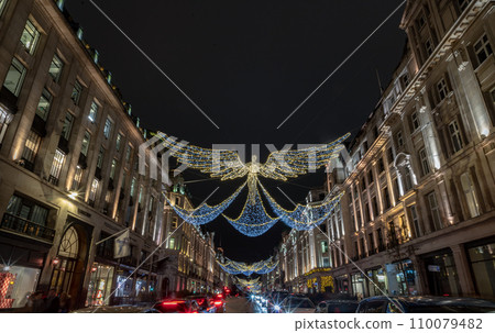 Flying angel Christmas decoration led lights display. Dramatic view of the traditional Christmas decoration lights hanging above Regent Street during dusk. 110079482