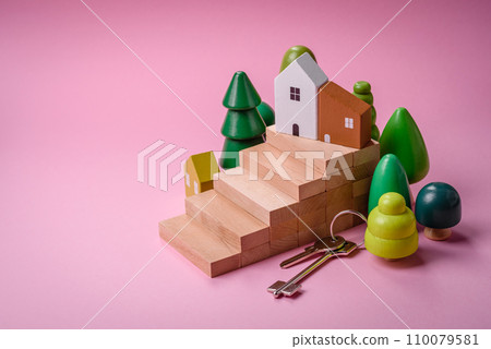 A small wooden house and keys as an idea for investing in your own home and achieving the goal of buying real estate 110079581