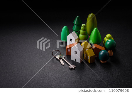 A small wooden house and keys as an idea for investing in your own home and achieving the goal of buying real estate 110079608