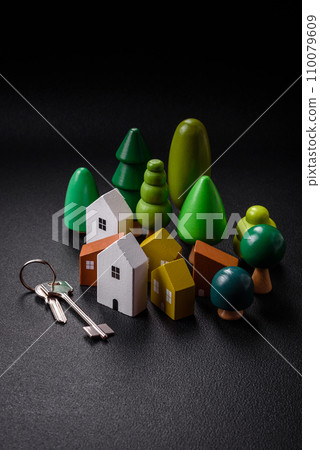 A small wooden house and keys as an idea for investing in your own home and achieving the goal of buying real estate 110079609