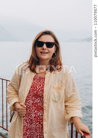 Happy brunette 30s woman enjoying summer holidays. Concept of vacation and travelling. Varenna, Italy. Lake Como 110079877
