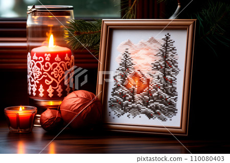 A framed embroidered christmas card with ornaments and candles on wooden table. Winter background with pine twigs A framed embroidered christmas card with ornaments and candles on wooden table. Winter background with pine twigs 110080403