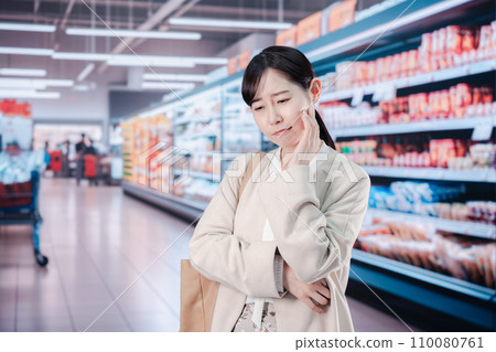 A woman suffering from high prices at a supermarket 110080761