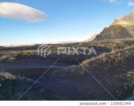 Northern region with black sand beach along shoreline and frozen Vestrahorn mountains range in Iceland. Spectacular Stokksnes beachfront with icelandic scenery and natural arctic skyline. 110081349
