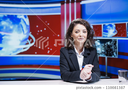 TV reporter presenting live information on television network, transmitting from media newsroom. Woman journalist addressing latest events and covering daily international topics. 110081387