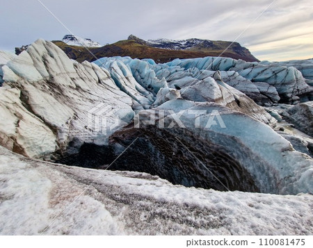 Frost covered Vatnajokull iceberg in Iceland with incredibly large glaciers painted white and blue. Arctic hills covered in snow and frozen icy cold water compose an icelandic picture. Frost covered Vatnajokull iceberg in Iceland with incredibly large glaciers painted white and blue. Arctic hills covered in snow and frozen icy cold water compose an icelandic picture. 110081475