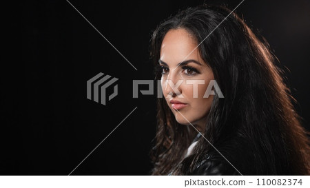 Young confident woman in a black studio environment 110082374