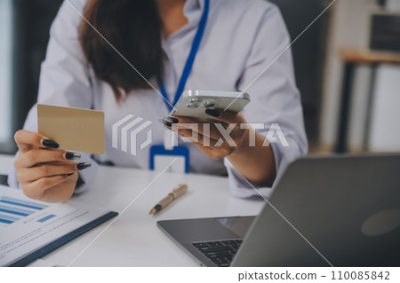 .Women holding credit card and using smartphones at home.Online shopping, internet banking, store online, payment, spending money, e-commerce payment at the store, credit card, concept .Women holding credit card and using smartphones at home.Online shopping, internet banking, store online, payment, spending money, e-commerce payment at the store, credit card, concept 110085842